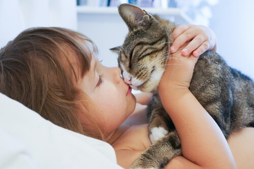 Menina beijando gato