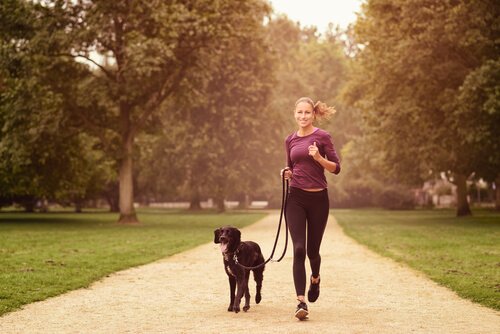 mulher correndo com cachorro: um dos benefícios de ter um animal de estimação