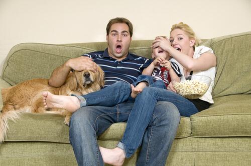 Família assistindo a um filme com cachorro