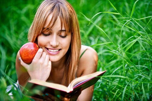 Mulher lendo com maçã