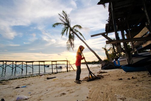 Mulher varrendo praia