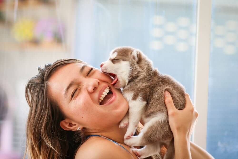 Mulher sorrindo com filhote de cachorro