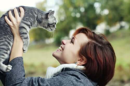 Mulher sorrindo para o seu gato